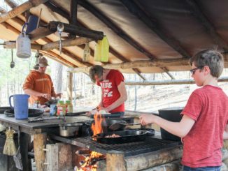 boys cooking a meal in outdoor kitchen